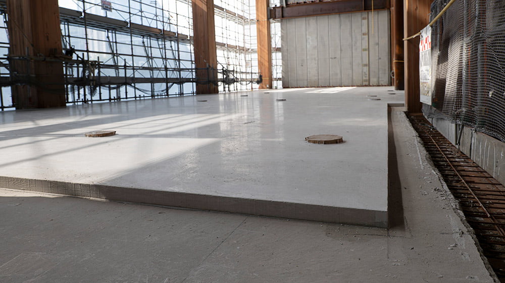 CLT床パネルの上にコンクリートと石膏系セルフレベリング材を施工